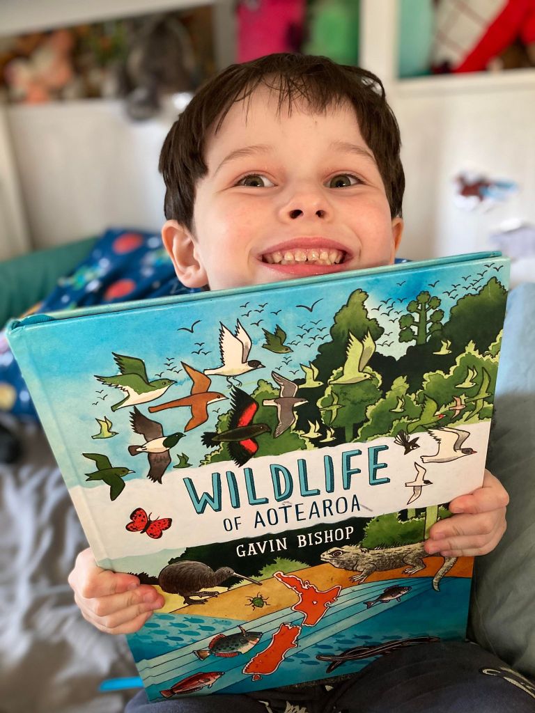 Noah holding Wildlife of Aotearoa book.